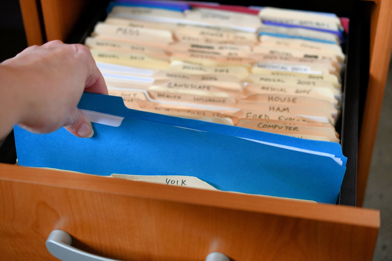 a female hand removing a folder from a cabinet ful 2023 11 27 05 09 18 utc